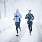 Two women run down Mountain Avenue in a snowstorm.