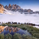 Mountain range reflected in lake at sunset with snow Dolomites I