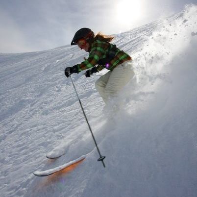 Smiling, bright colours, hands up front, on top of your skis