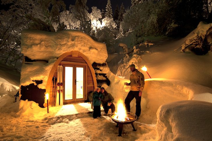 PodHotel-Hütte mit Campern, die ein Feuer im Freien genießen