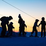 Ski family at a Grand Massif ski area sunset.